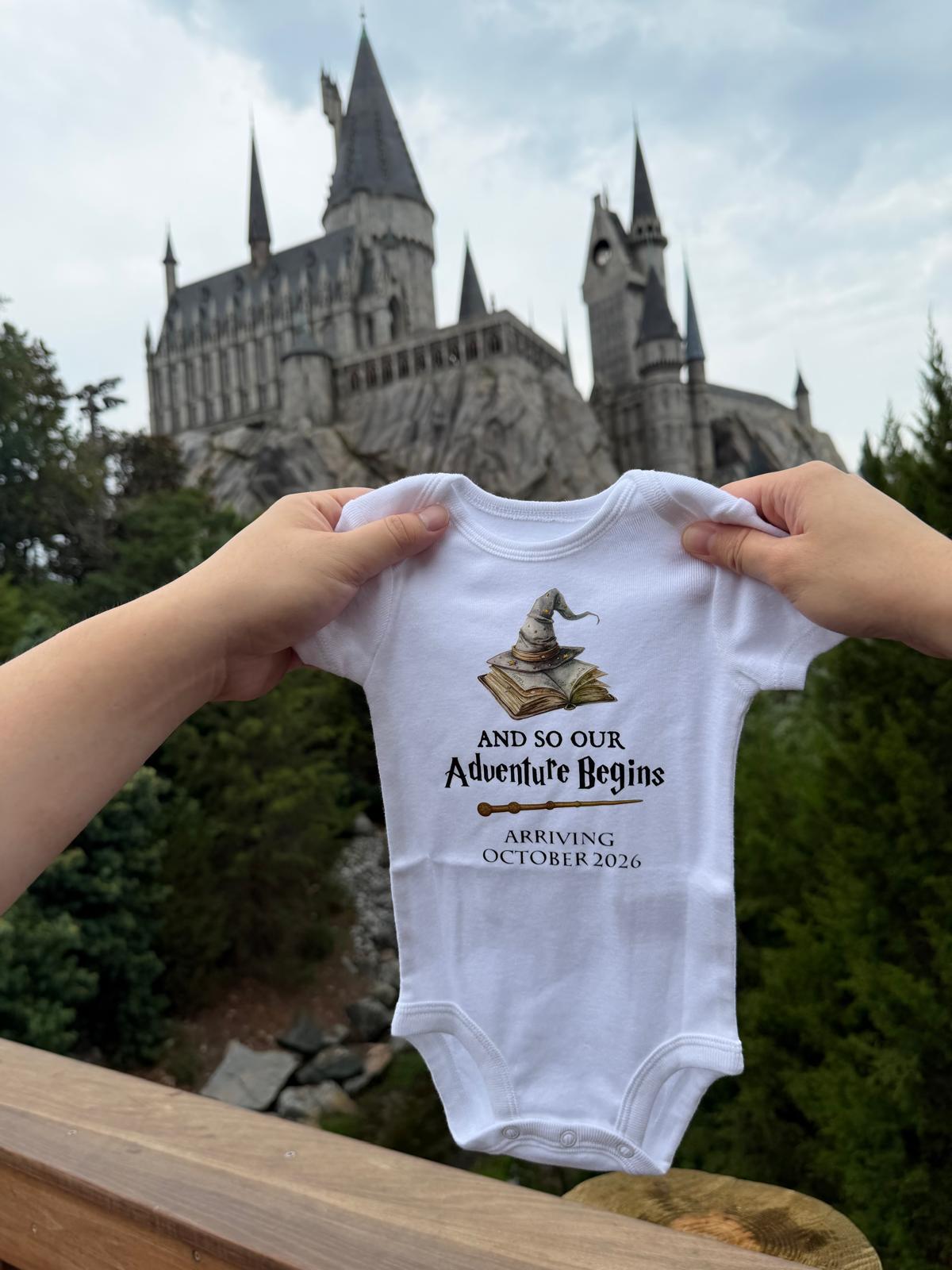 Baby onesie with a wizard sorting hat and the words 'And so our adventure begins'